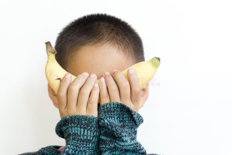 Behandla som ett barn rymma en banan stängda ögon, utan att se framsidan arkivbild Behandla som ett barn rymma en banan stängda ögon, utan att se framsidan arkivbild
