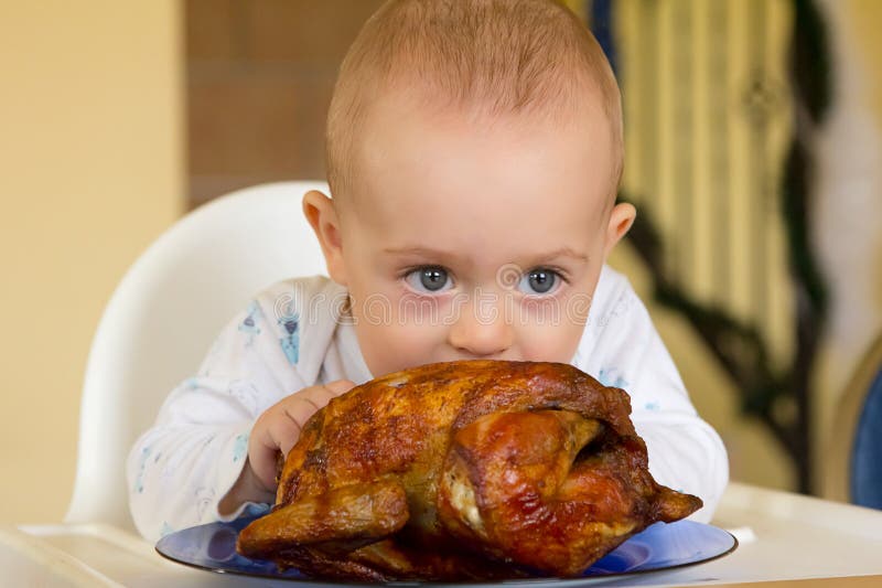 One year old baby boy eating a big grilled chicken. One year old baby boy eating a big grilled chicken