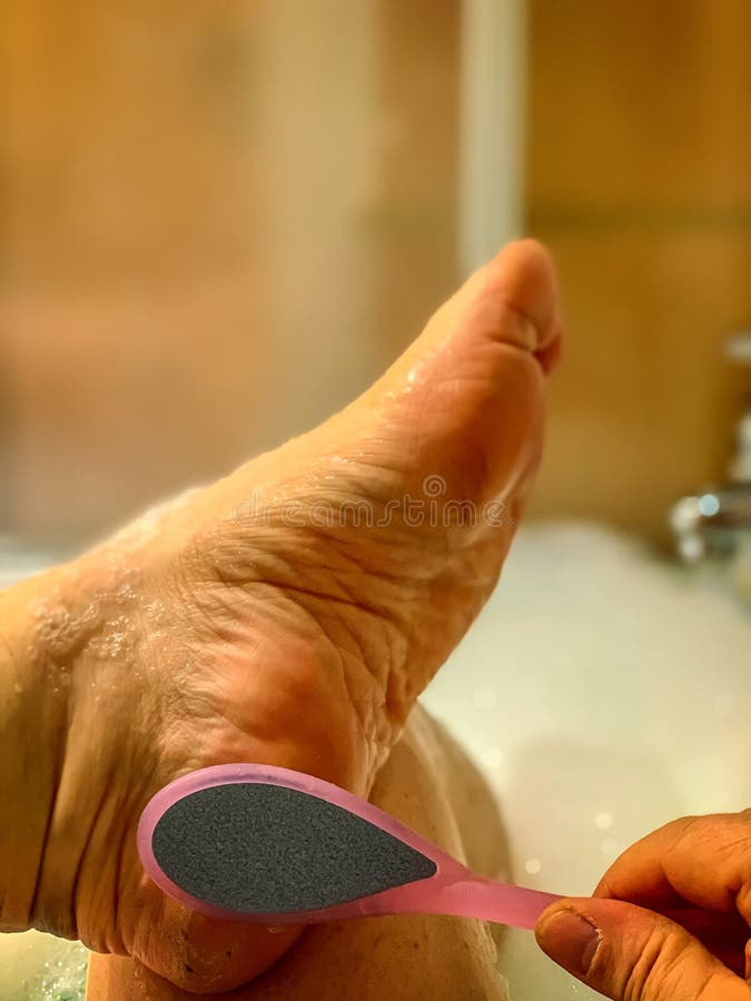 Treatment like grinding the heel in the bath. Concept: hygiene and care. Treatment like grinding the heel in the bath. Concept: hygiene and care
