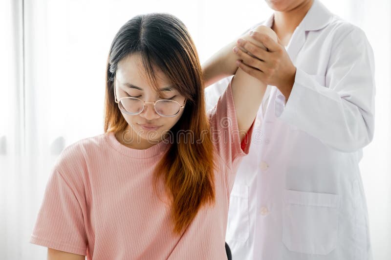 Behandlingsterapi hos honläkare genom förlängning av en patients smärtbog.. behandling med sträckövningar royaltyfri fotografi