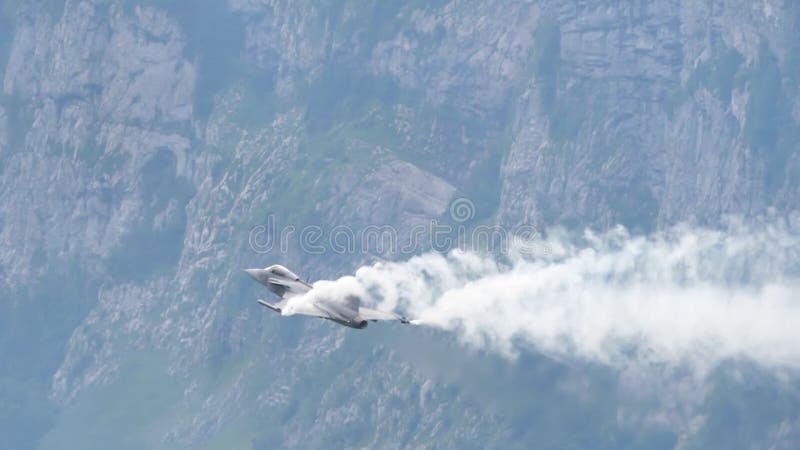 Behind view of fighter jet plane flying at high angle of attack in slow motion