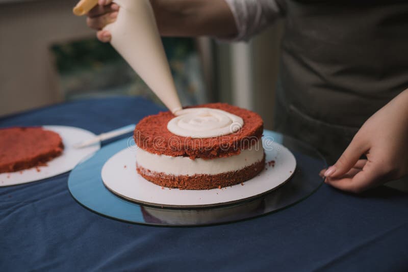 Behållaren klämmer krämen på tårtan Flickor som gör en kaka royaltyfri foto Behållaren klämmer krämen på tårtan Flickor som gör en kaka royaltyfri foto