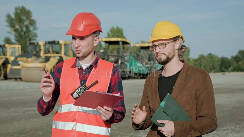 Behörig byggare som kontrollerar arbetet på byggarbetsplatsen utanför royaltyfri foto