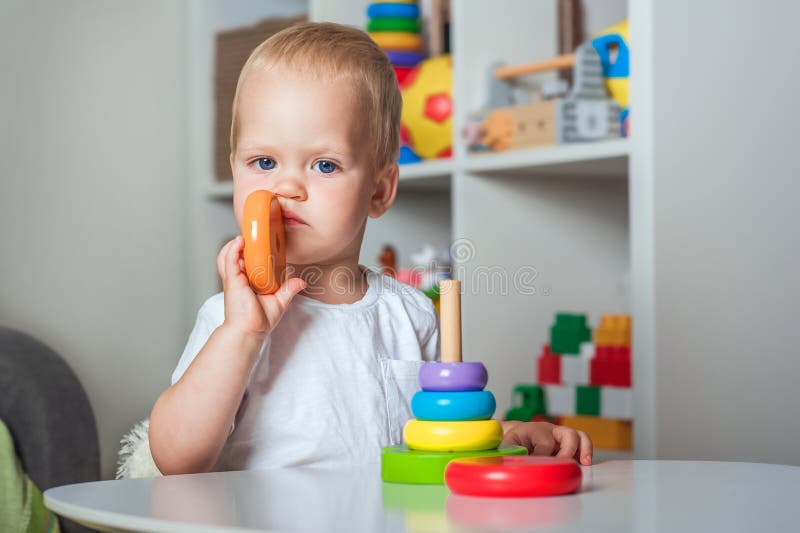 Bei bambini giocano con giocattoli in legno in asili d'infanzia o in locali chiusi per bambini e copiano spazio fotografia stock libera da diritti