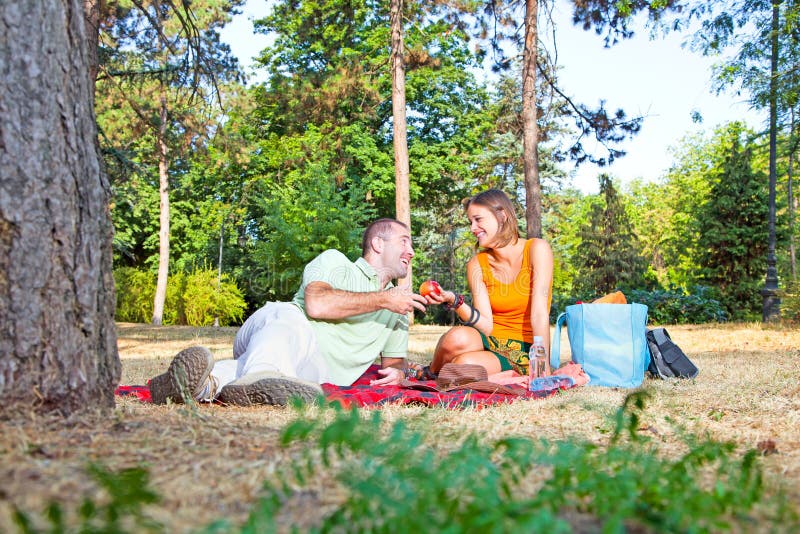 Bei giovane e donna sul picnic in foresta fotografia stock Bei giovane e donna sul picnic in foresta fotografia stock