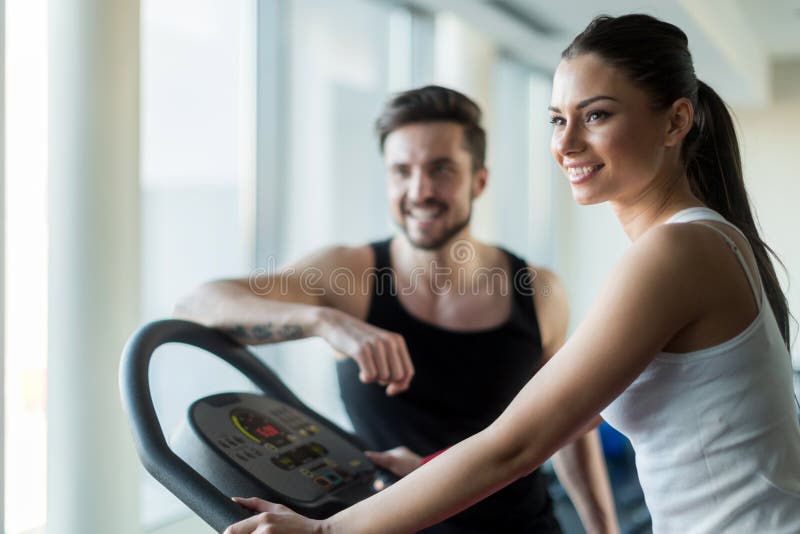 Bei, giovani che parlano in una palestra mentre risolvendo fotografia stock Bei, giovani che parlano in una palestra mentre risolvendo fotografia stock