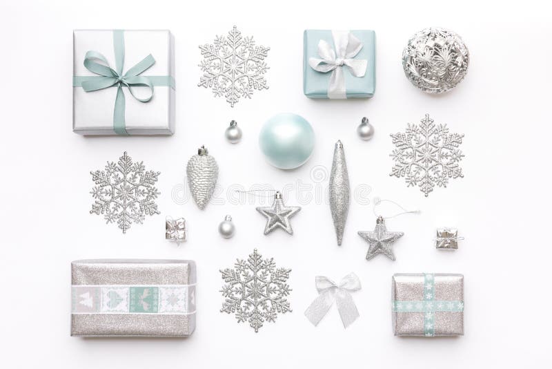 Bei regali di natale e fiocchi di neve ed ornamenti d'argento isolati su fondo bianco Composizione in natale