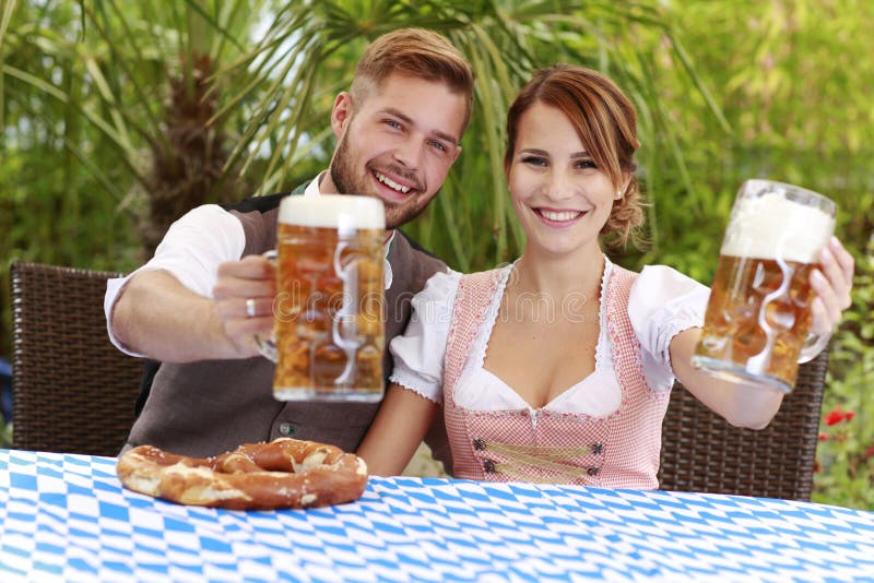 Beiers Paar in Traditioneel Kostuum Met Bier En Brezel Stock Afbeelding ...