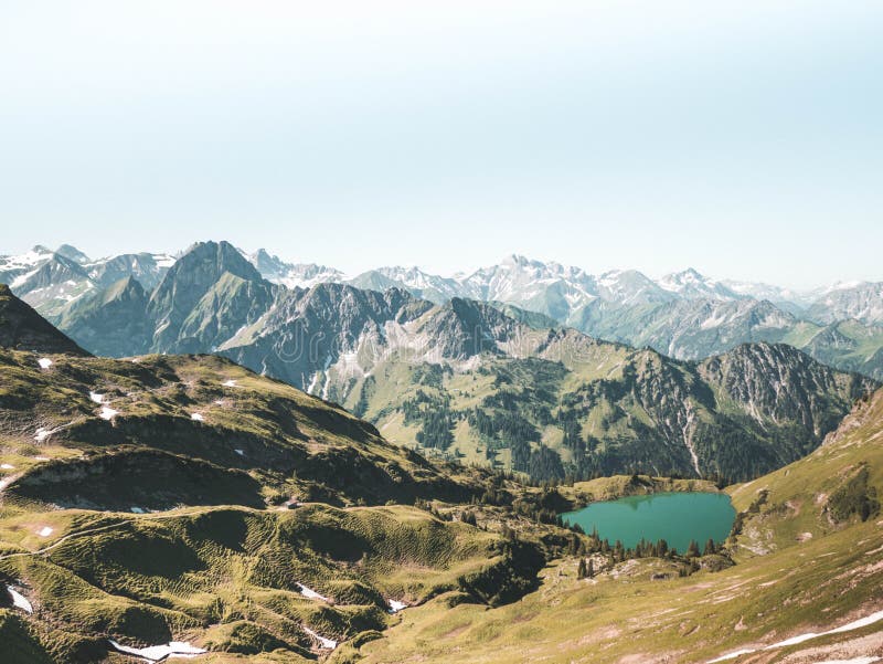 Beige And Green Mountain With Teal Lake Under White Sky At Daytime ...