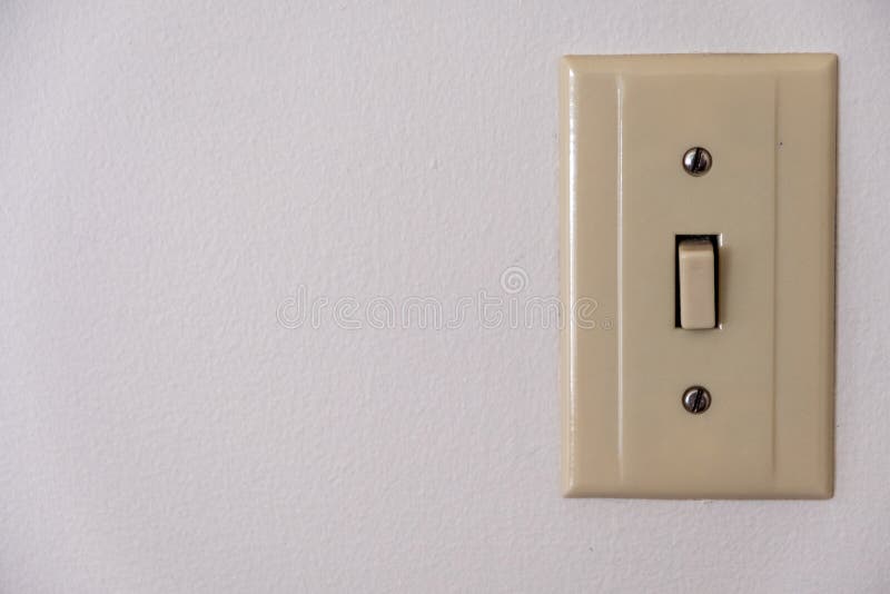 Beige, Plastic Light Switch on the Right Side of a White Wall Stock