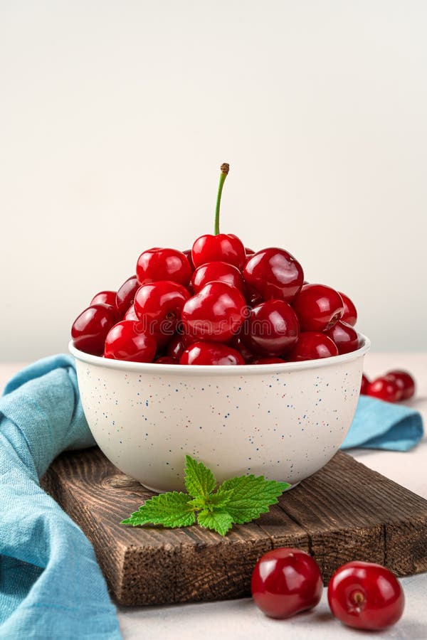 Beige plate with large ripe cherries. Side view, vertical. A natural, healthy fruit.