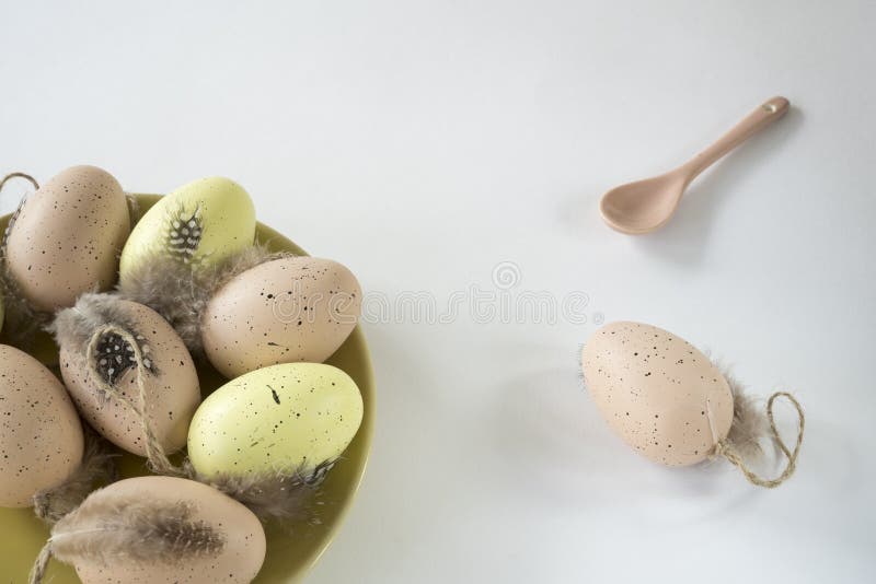 Beige, rosa y huevos de Pascua amarillos en la placa, en la tabla blanca, con la copia de cerámica de la cuchara foto de archivo libre de regalías Beige, rosa y huevos de Pascua amarillos en la placa, en la tabla blanca, con la copia de cerámica de la cuchara foto de archivo libre de regalías