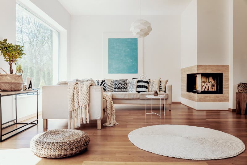Beige und weiße Gewebe und ein modernes kugelförmiges hängendes Licht in einem sonnigen, ruhigen Wohnzimmerinnenraum mit natürlic