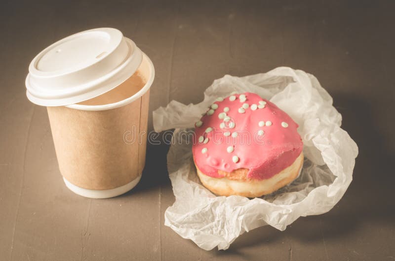 beignet dans le lustre rouge et une tasse de café de papier/beignet dans le lustre rouge et une tasse de café de papier sur une t photographie stock beignet dans le lustre rouge et une tasse de café de papier/beignet dans le lustre rouge et une tasse de café de papier sur une t photographie stock