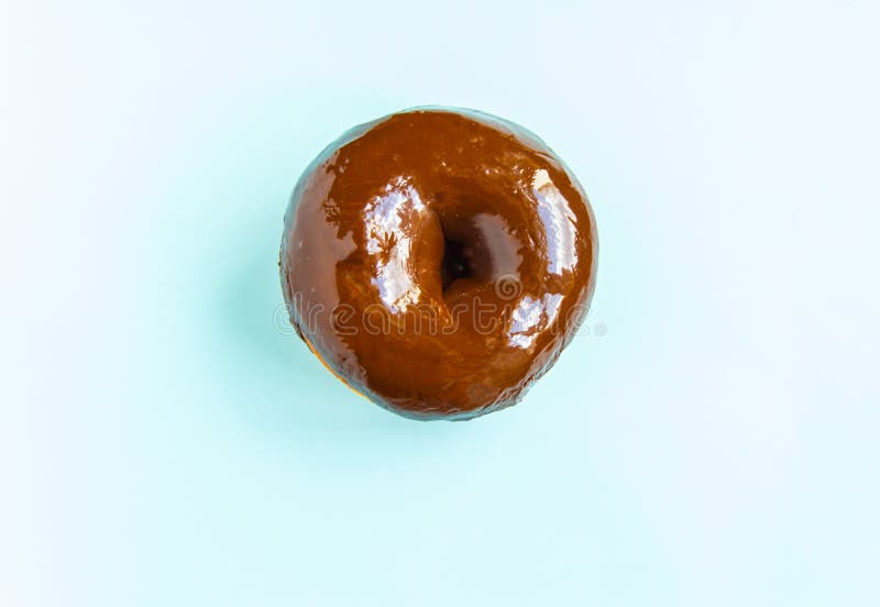 Beignet de Dlicious avec un lustre brillant de miroir de chocolat d'isolement sur un fond bleu La vue ? partir du dessus photos stock Beignet de Dlicious avec un lustre brillant de miroir de chocolat d'isolement sur un fond bleu La vue ? partir du dessus photos stock