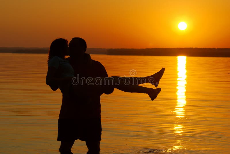 Beijando pares na praia fotografia de stock Beijando pares na praia fotografia de stock