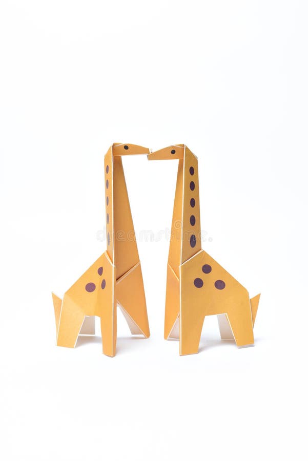 Beijo amarelo dos pares dos girafas do origâmi imagem de stock royalty free Beijo amarelo dos pares dos girafas do origâmi imagem de stock royalty free