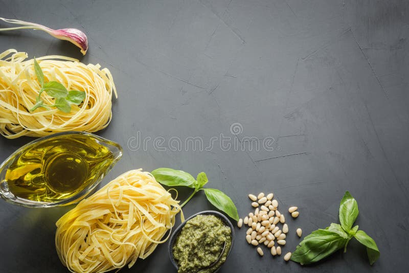 Beira do trigo de trigo duro cru da massa, pesto, manjericão, Parmesão para cozinhar pratos mediterrâneos Vista superior, espaço imagens de stock Beira do trigo de trigo duro cru da massa, pesto, manjericão, Parmesão para cozinhar pratos mediterrâneos Vista superior, espaço imagens de stock