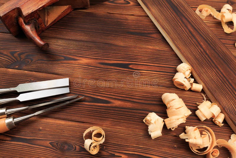 Beitelsvliegtuig en zaagsel op een houten lijst stock afbeelding Beitelsvliegtuig en zaagsel op een houten lijst stock afbeelding
