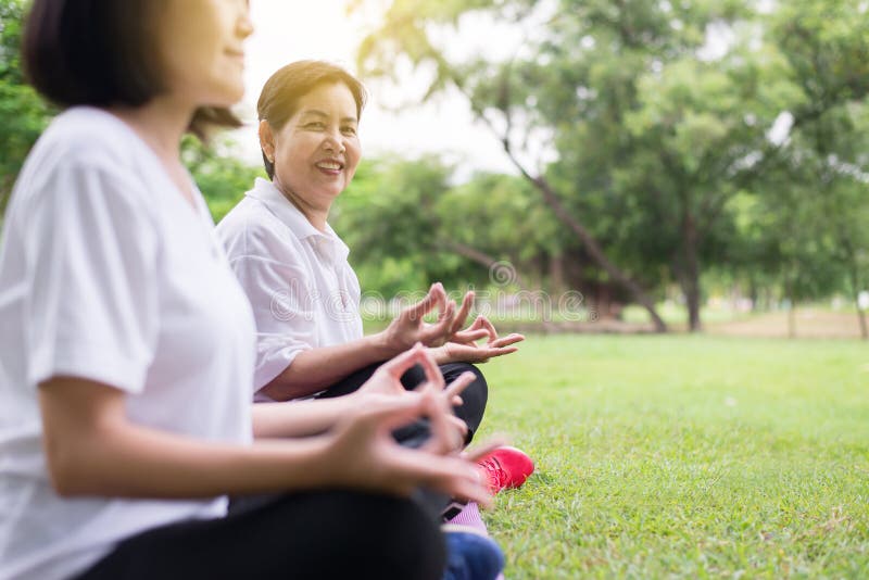 Bejaarde Aziatische vrouw het praktizeren yogazitting bij park in de ochtend, Gelukkig en het glimlachen, het Positieve denken, G royalty-vrije stock afbeelding Bejaarde Aziatische vrouw het praktizeren yogazitting bij park in de ochtend, Gelukkig en het glimlachen, het Positieve denken, G royalty-vrije stock afbeelding