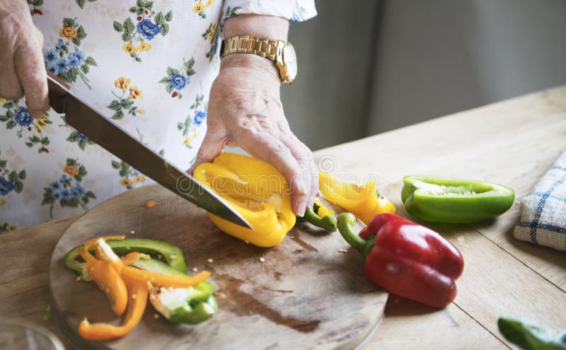 Bejaarde snijdende groene paprika's royalty-vrije stock afbeeldingen Bejaarde snijdende groene paprika's royalty-vrije stock afbeeldingen