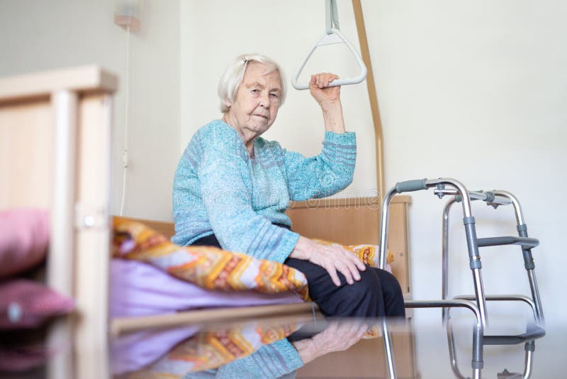 Elderly 96 years old woman sitting on medical bed in hospic. Palliative health care support for older people concept. Care for the elderly. Elderly 96 years old woman sitting on medical bed in hospic. Palliative health care support for older people concept. Care for the elderly.