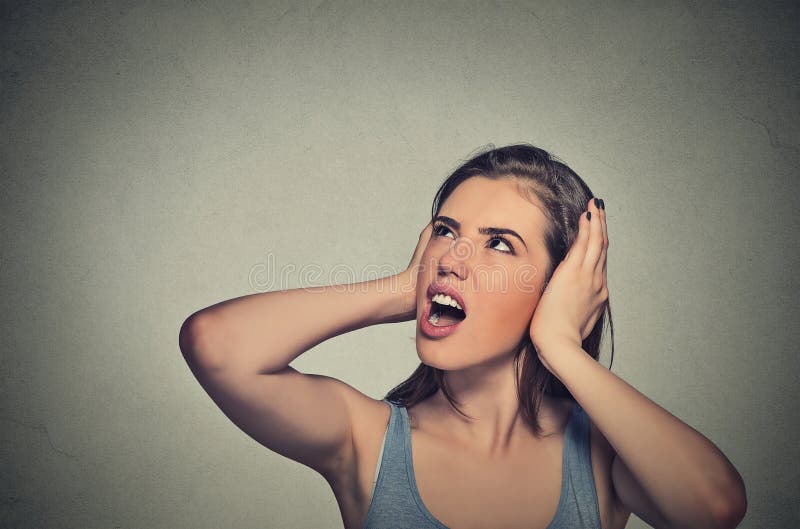 Beklemtoonde vrouw die haar oren behandelen die omhoog eruit zien stock afbeeldingen Beklemtoonde vrouw die haar oren behandelen die omhoog eruit zien stock afbeeldingen