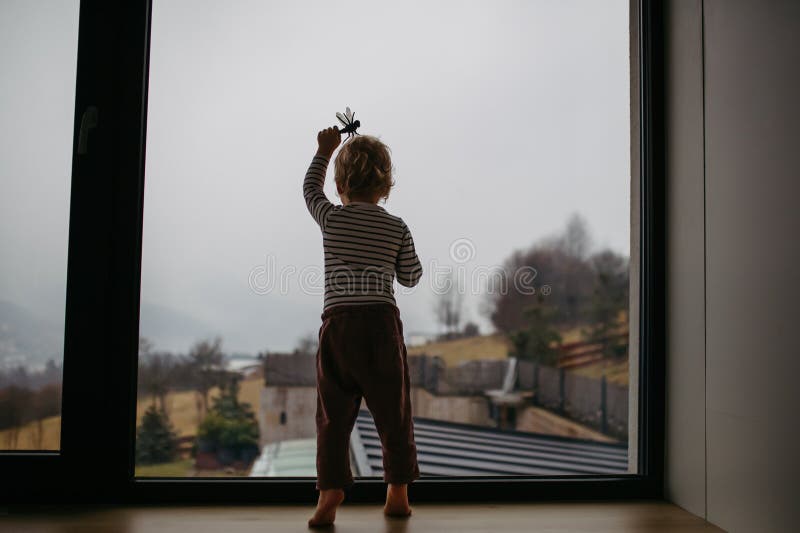 Bekvämt barn leker med leksak hemma. arkivbild