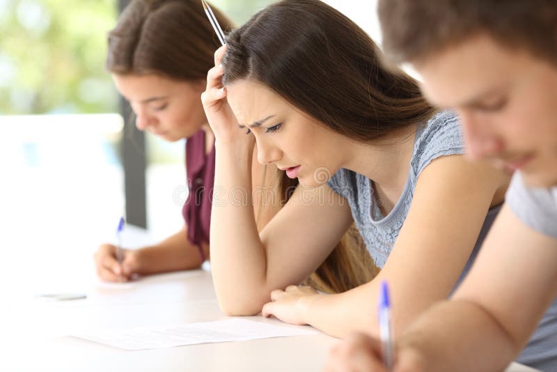 Bekymrad student som försöker att göra en svår examen arkivbild Bekymrad student som försöker att göra en svår examen arkivbild
