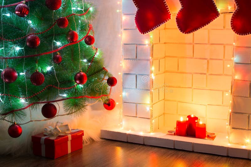 Bel arbre décoré avec des présents sur le plancher près de la cheminée avec la lumière chaude des bougies photos libres de droits Bel arbre décoré avec des présents sur le plancher près de la cheminée avec la lumière chaude des bougies photos libres de droits