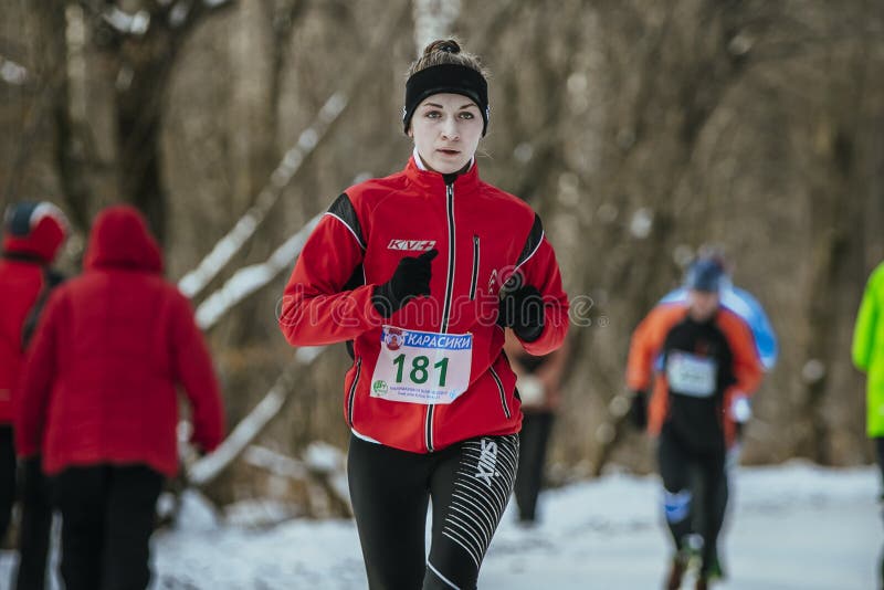 Bel athlète de fille courant en bas du parc d'hiver d'allée image stock Bel athlète de fille courant en bas du parc d'hiver d'allée image stock
