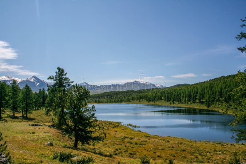 Bel horizontal de montagne Montagnes couronnées de neige, lac image stock Bel horizontal de montagne Montagnes couronnées de neige, lac image stock