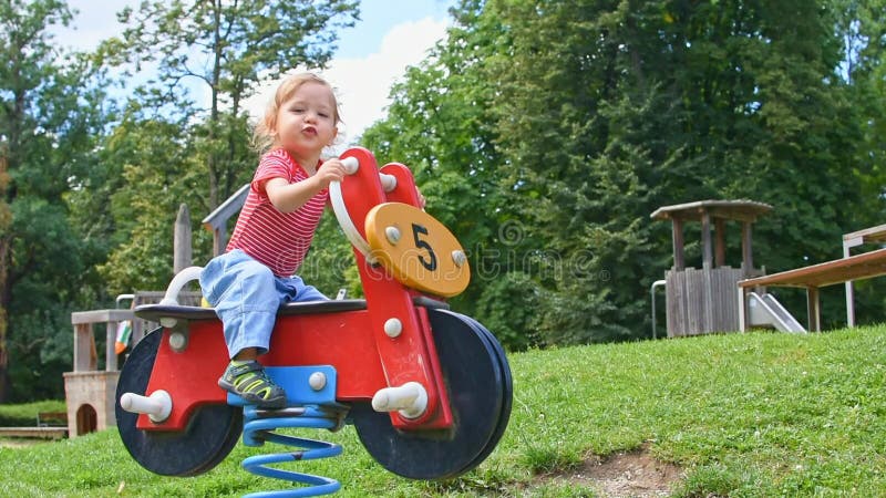 Bel ragazzino che si diverte a giocare con giochi di legno colorati nel parco bella giornata di sole estivo nei bambini al parco stock footage