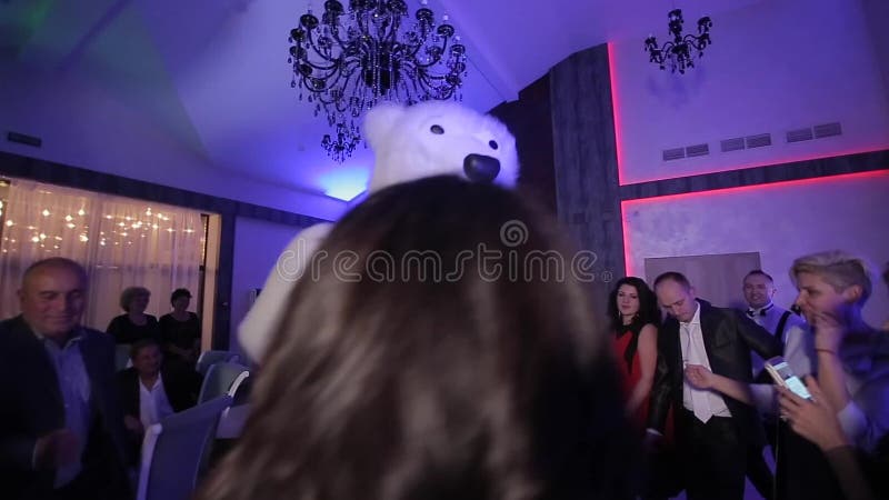 Belarus, Minsk - January 15, 2019: Wedding party. Man in a big polar bear costume is dancing at a wedding with the bride