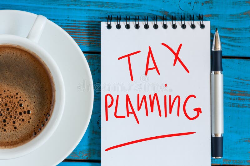 Tax planning, reminder with red ink in the diary near morning coffee cup. top view. Tax planning, reminder with red ink in the diary near morning coffee cup. top view.