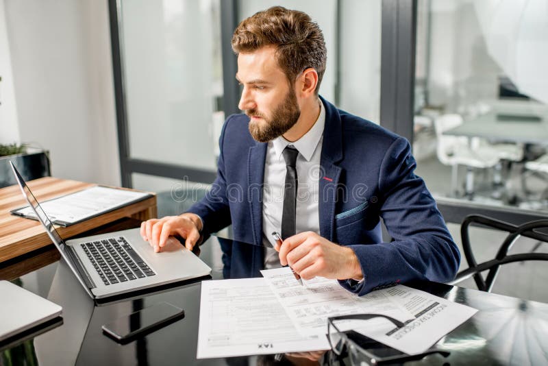 Belastingsmanager die op het kantoor werken royalty-vrije stock afbeeldingen Belastingsmanager die op het kantoor werken royalty-vrije stock afbeeldingen