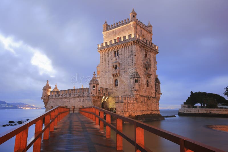 Belem Tower designed by architect Francisco de Arruda at twilight with River Tagus Estuary in background