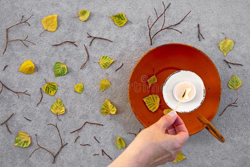 Beleuchten einer Kerze für gemütliche Herbststimmung stockfotografie