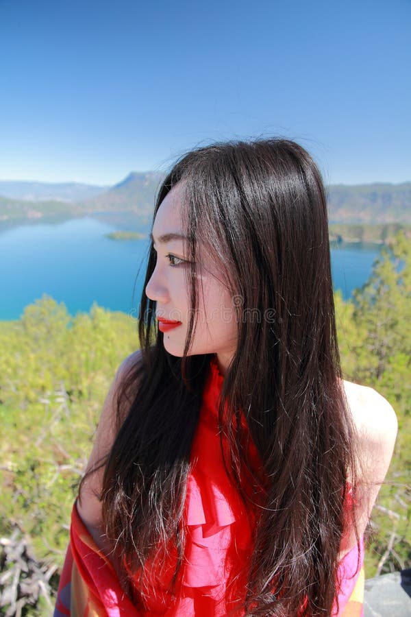 A beleza chinesa asiática no vestido vermelho aprecia a vida calma e feliz foto de stock A beleza chinesa asiática no vestido vermelho aprecia a vida calma e feliz foto de stock