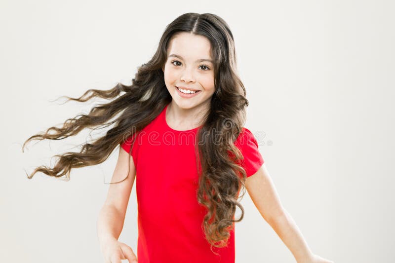 Menina bonita pulando e dançando em casa cabelo cacheado estilo casual  suéter branco feliz