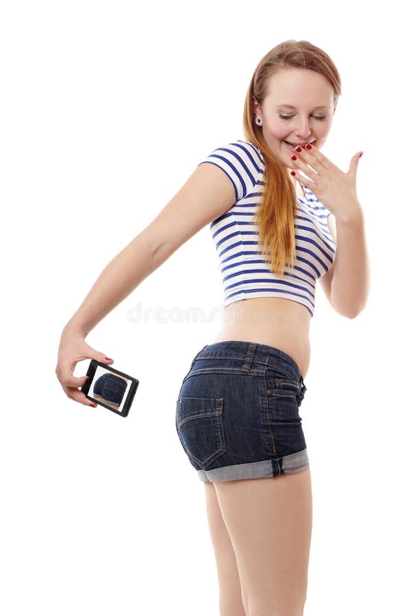 Cheeky young woman taking a belfie or selfie