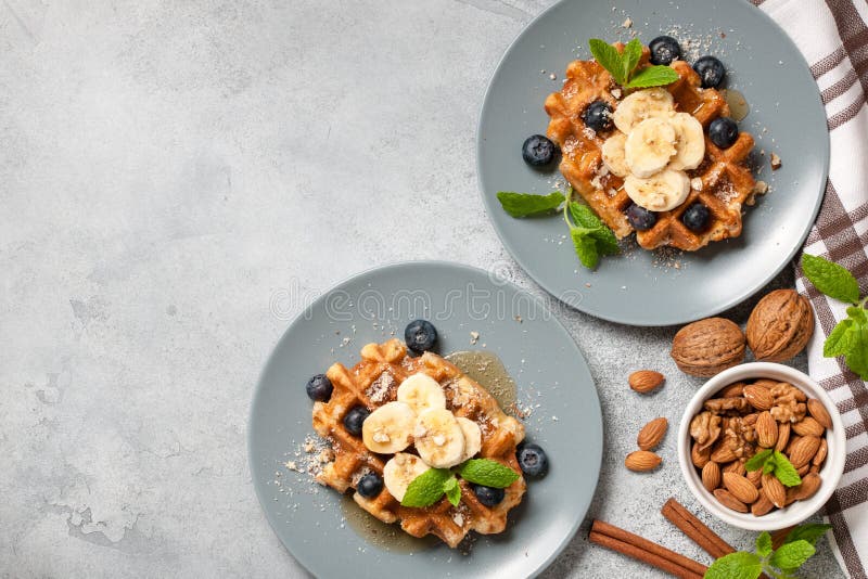 Belgian Waffle with Honey, Banana, Nuts and Blueberries Stock Photo