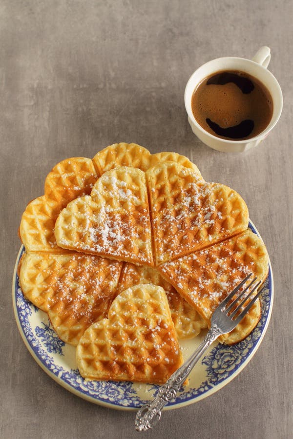 Heart shaped waffle with cup of coffee. Belgian waffles with powder sugar for serving with coffee top view stock photography Heart shaped waffle with cup of coffee. Belgian waffles with powder sugar for serving with coffee top view stock photography
