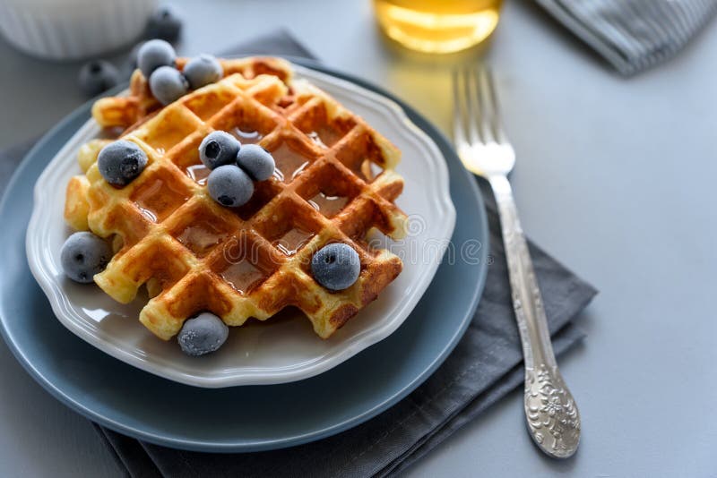 Belgische wafels met bosbessen en honing op grijze houten achtergrond Eigengemaakte gezonde ontbijt Selectieve nadruk royalty-vrije stock fotografie Belgische wafels met bosbessen en honing op grijze houten achtergrond Eigengemaakte gezonde ontbijt Selectieve nadruk royalty-vrije stock fotografie