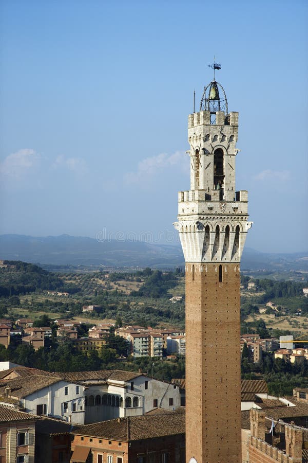 Bell tower of the Palazzo Pubblico, and surrounding buildings, in Siena, Italy. Vertical shot. Bell tower of the Palazzo Pubblico, and surrounding buildings, in Siena, Italy. Vertical shot.