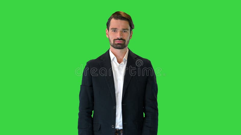 Bell'uomo con un vestito che spinge bottoni virtuali che presentano qualcosa sullo schermo verde, chroma.