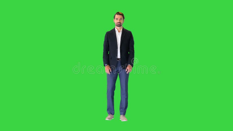 Bell'uomo con un vestito che spinge bottoni virtuali che presentano qualcosa sullo schermo verde, chroma.