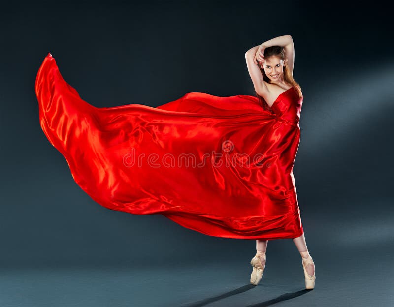Bella ballerina del ballerino che balla un volo rosso lungo del vestito fotografie stock Bella ballerina del ballerino che balla un volo rosso lungo del vestito fotografie stock