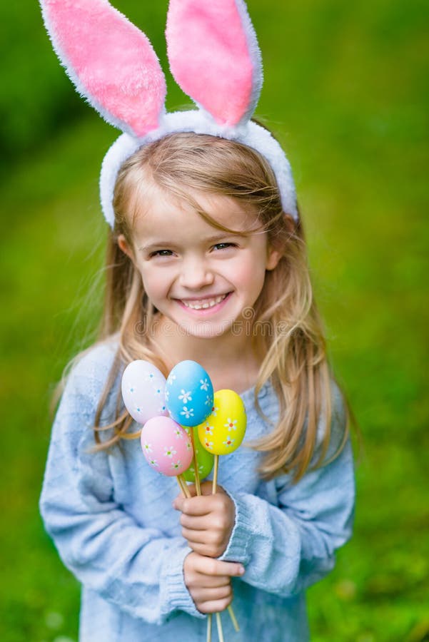 Bella bambina sorridente che indossa le orecchie rosa del coniglietto o del coniglio immagini stock Bella bambina sorridente che indossa le orecchie rosa del coniglietto o del coniglio immagini stock