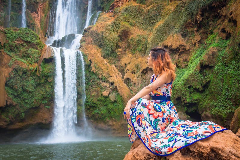 Bella cascata nel Marocco Indietro della donna in bello vestito che guarda caduta Ouzoud Natura esotica del Nord Africa, fotografie stock libere da diritti Bella cascata nel Marocco Indietro della donna in bello vestito che guarda caduta Ouzoud Natura esotica del Nord Africa, fotografie stock libere da diritti